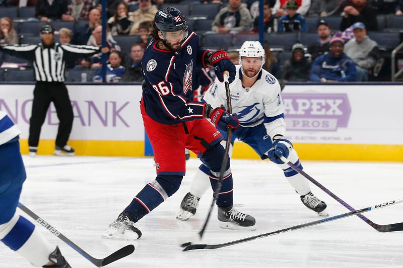 Nov 21, 2024; Columbus, Ohio, USA; Columbus Blue Jackets right wing Kirill Marchenko (86) shoots on goal as Tampa Bay Lightning center Luke Glendening (11) trails the play during the second period at Nationwide Arena. Mandatory Credit: Russell LaBounty-Imagn Images