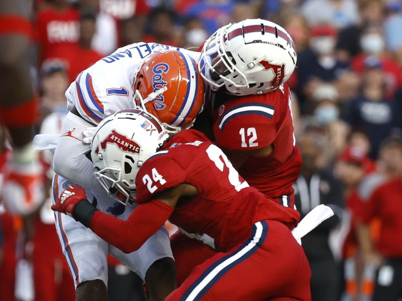 Sep 4, 2021; Gainesville, Florida, USA; Florida Gators wide receiver Jacob Copeland (1) runs with the ball as  Florida Atlantic Owls cornerback Zyon Gilbert (24) and  cornerback Diashun Moss (12) tackle during the first quarter at Ben Hill Griffin Stadium. Mandatory Credit: Kim Klement-USA TODAY Sports