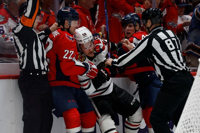 Apr 4, 2025; Washington, District of Columbia, USA; Washington Capitals right wing Brandon Duhaime (22) grabs Chicago Blackhawks left wing Tyler Bertuzzi (59) during a scrum in the third period at Capital One Arena. Mandatory Credit: Geoff Burke-Imagn Images