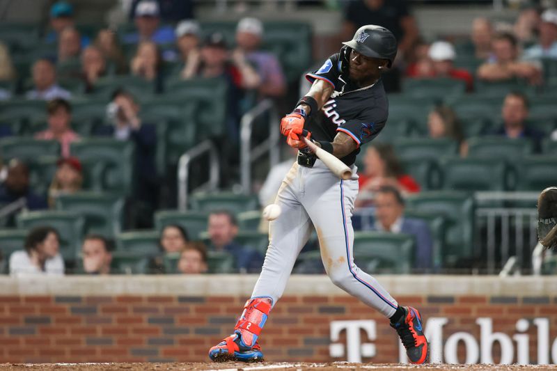 Apr 24, 2024; Atlanta, Georgia, USA; Miami Marlins center fielder Jazz Chisholm Jr. (2) hits a single against the Atlanta Braves in the ninth inning at Truist Park. Mandatory Credit: Brett Davis-USA TODAY Sports