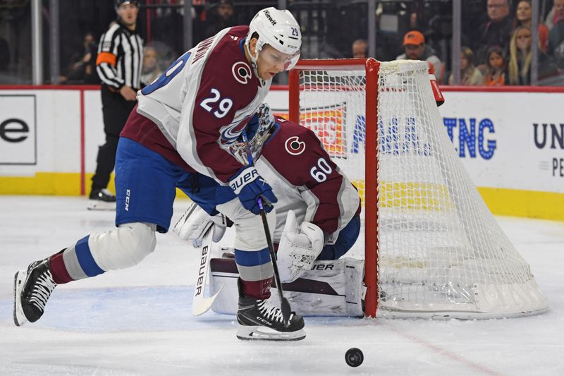 Nov 18, 2024; Philadelphia, Pennsylvania, USA; Colorado Avalanche center Nathan MacKinnon (29) clears the puck away from goaltender Justus Annunen (60) against the Philadelphia Flyers during the first period at Wells Fargo Center. Mandatory Credit: Eric Hartline-Imagn Images