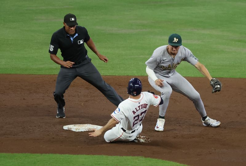 Sep 10, 2024; Houston, Texas, USA;  Houston Astros second baseman Jose Altuve (27) tags up from first base to second base as Oakland Athletics second baseman Zack Gelof (20) is late with the tag in the third inning at Minute Maid Park. Mandatory Credit: Thomas Shea-Imagn Images