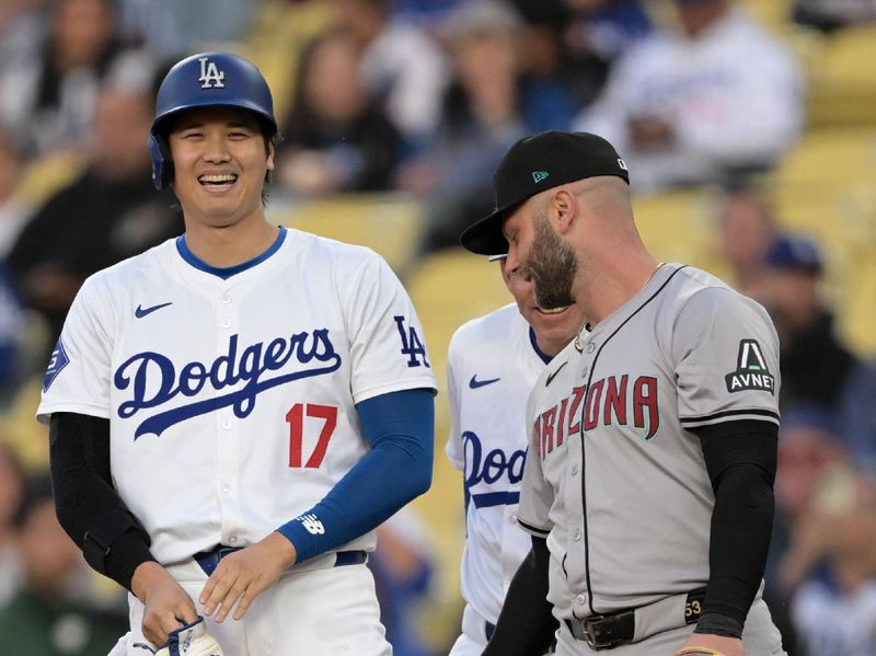 May 20, 2024; Los Angeles, California, USA;  Los Angeles Dodgers designated hitter Shohei Ohtani (17) laughs with Arizona Diamondbacks first baseman Christian Walker (53) after he is safe at first on a bunt single in the first inning at Dodger Stadium. Mandatory Credit: Jayne Kamin-Oncea-USA TODAY Sports