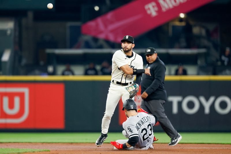 Jun 17, 2023; Seattle, Washington, USA; Seattle Mariners second baseman Jose Caballero (76) turns a double play against Chicago White Sox left fielder Andrew Benintendi (23) during the first inning at T-Mobile Park. Mandatory Credit: Joe Nicholson-USA TODAY Sports