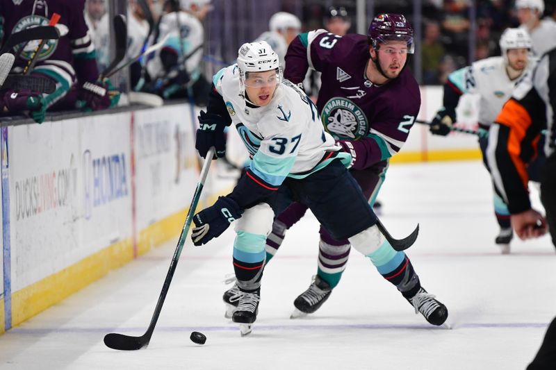 Dec 23, 2023; Anaheim, California, USA; Seattle Kraken center Yanni Gourde (37) moves the puck ahead of Anaheim Ducks center Mason McTavish (23) during the third period at Honda Center. Mandatory Credit: Gary A. Vasquez-USA TODAY Sports