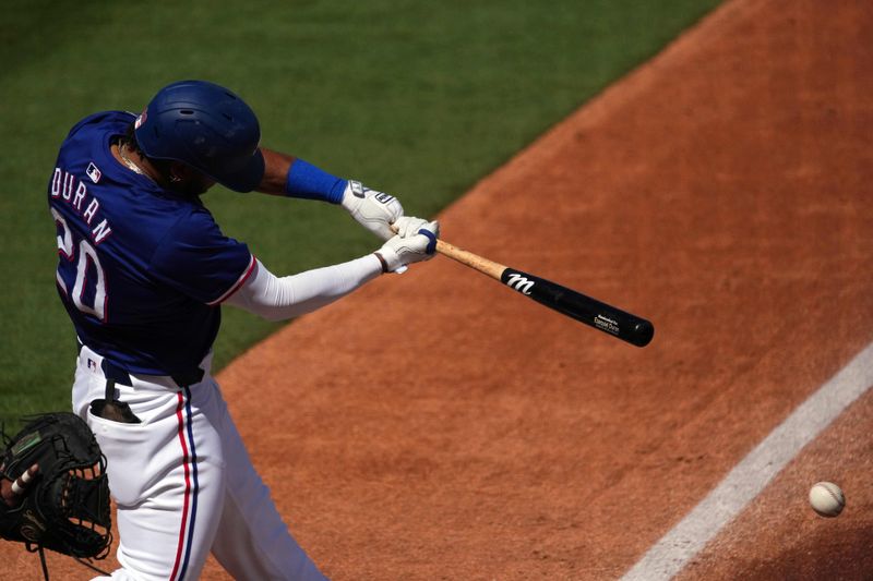 Mar 8, 2024; Surprise, Arizona, USA; Texas Rangers shortstop Ezequiel Duran (20) bats against the Kansas City Royals during the second inning at Surprise Stadium. Mandatory Credit: Joe Camporeale-USA TODAY Sports