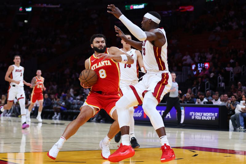 MIAMI, FLORIDA - OCTOBER 16: David Roddy #8 of the Atlanta Hawks drives against Bam Adebayo #13 of the Miami Heat during the second quarter of a preseason game at Kaseya Center on October 16, 2024 in Miami, Florida. NOTE TO USER: User expressly acknowledges and agrees that, by downloading and or using this photograph, User is consenting to the terms and conditions of the Getty Images License Agreement. (Photo by Megan Briggs/Getty Images)