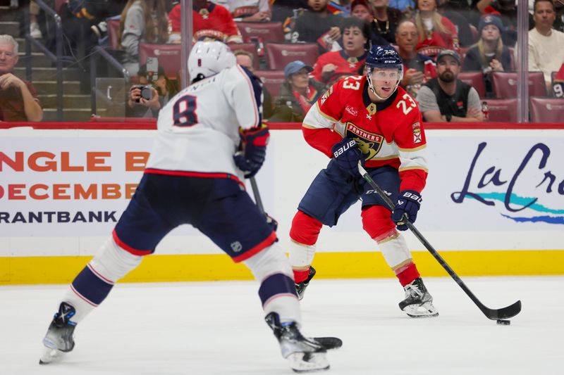 Nov 6, 2023; Sunrise, Florida, USA; Florida Panthers center Carter Verhaeghe (23) moves the puck against Columbus Blue Jackets defenseman Zach Werenski (8) during the second period at Amerant Bank Arena. Mandatory Credit: Sam Navarro-USA TODAY Sports