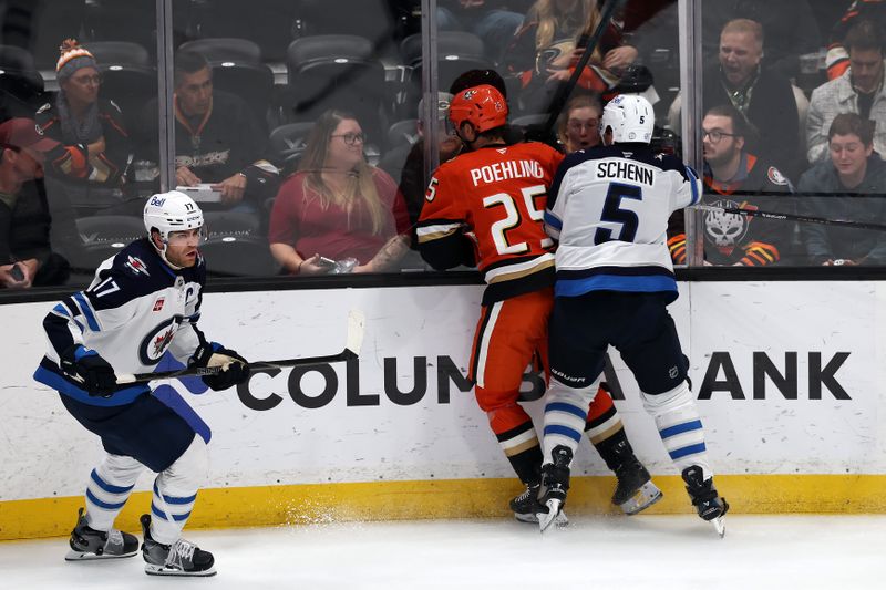 Nov 9, 2025; Anaheim, California, USA;  Winnipeg Jets defenseman Luke Schenn (5) checks Anaheim Ducks center Ryan Poehling (25) during the third period at Honda Center. Mandatory Credit: Kiyoshi Mio-Imagn Images