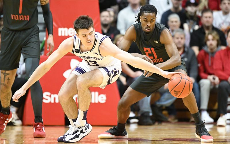 Feb 18, 2024; Bloomington, Indiana, USA;  Northwestern Wildcats guard Brooks Barnhizer (13) reaches for the ball in front of Indiana Hoosiers forward Mackenzie Mgbako (21) during the first half at Simon Skjodt Assembly Hall. Mandatory Credit: Robert Goddin-USA TODAY Sports