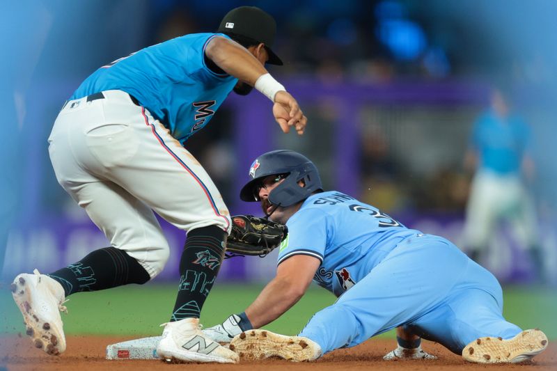 Aug 24, 2025; Miami, Florida, USA; Toronto Blue Jays left fielder Davis Schneider (36) steals second base against Miami Marlins shortstop Otto Lopez (6) during the fifth inning at loanDepot Park. Mandatory Credit: Sam Navarro-Imagn Images