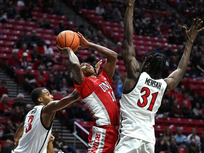 Feb 11, 2023; San Diego, California, USA; UNLV Rebels guard Keshon Gilbert (10) shoots the ball while defended by San Diego State Aztecs forward Nathan Mensah (31) during the second half at Viejas Arena. Mandatory Credit: Orlando Ramirez-USA TODAY Sports