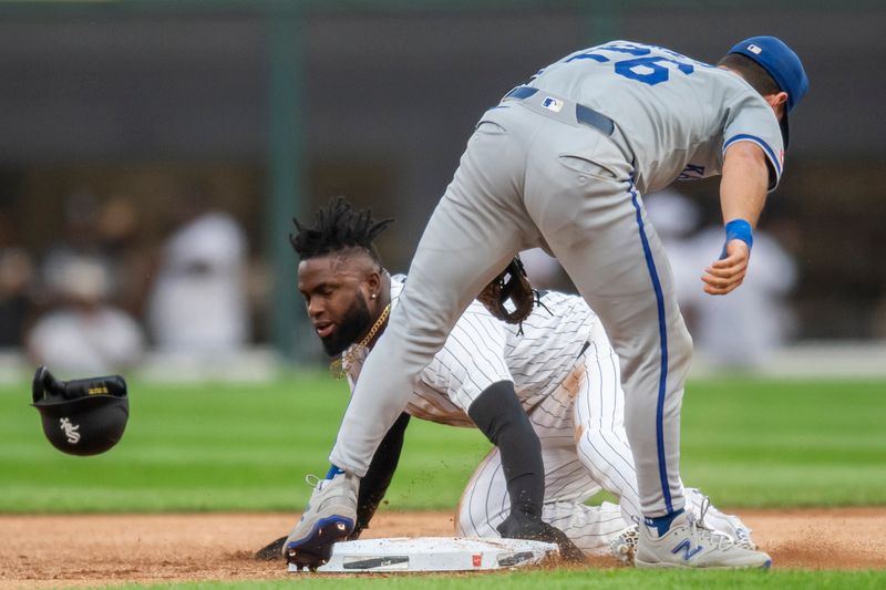 Jul 30, 2024; Chicago, Illinois, USA; Chicago White Sox center fielder Luis Robert Jr. (88) is caught stealing second base as Kansas City Royals second base Adam Frazier (26) tags him out during the first inning at Guaranteed Rate Field. Mandatory Credit: Patrick Gorski-USA TODAY Sports