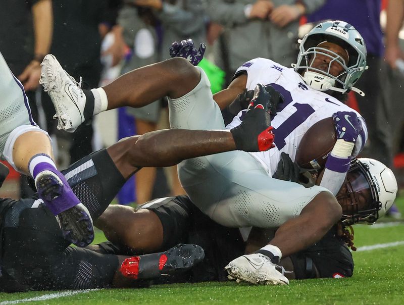 Nov 2, 2024; Houston, Texas, USA; Kansas State Wildcats running back DJ Giddens (31) is tackled by Houston Cougars defensive back Hershey McLaurin (15) for a loss in the first quarter at TDECU Stadium. Mandatory Credit: Thomas B. Shea-Imagn Images