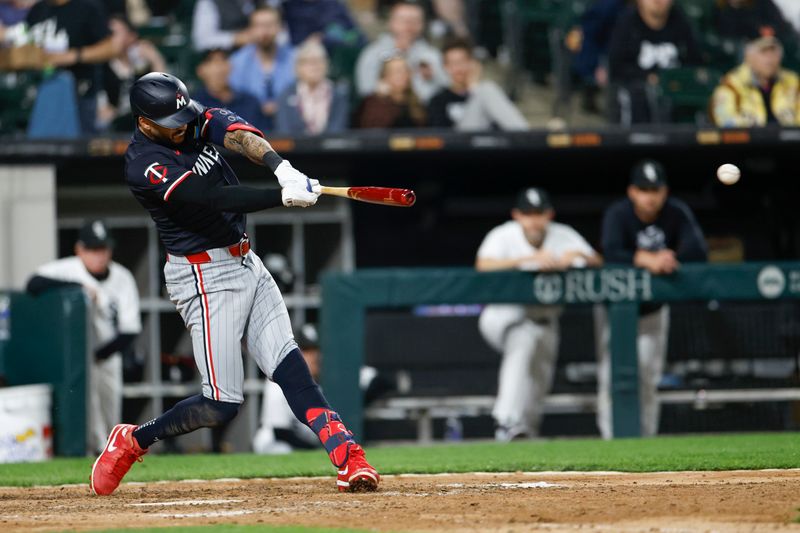 Apr 30, 2024; Chicago, Illinois, USA; Minnesota Twins shortstop Carlos Correa (4) hits an RBI-single against the Chicago White Sox during the eight inning at Guaranteed Rate Field. Mandatory Credit: Kamil Krzaczynski-USA TODAY Sports