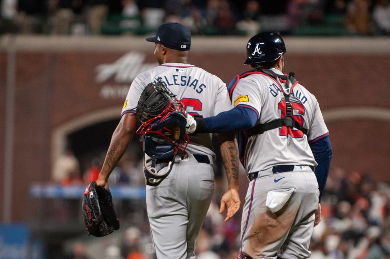 Aug 13, 2024; San Francisco, California, USA;  Atlanta Braves pitcher Raisel Iglesias (26) and catcher Travis d'Arnaud (16) embrace after defeating the San Francisco Giants at Oracle Park. Mandatory Credit: Ed Szczepanski-USA TODAY Sports