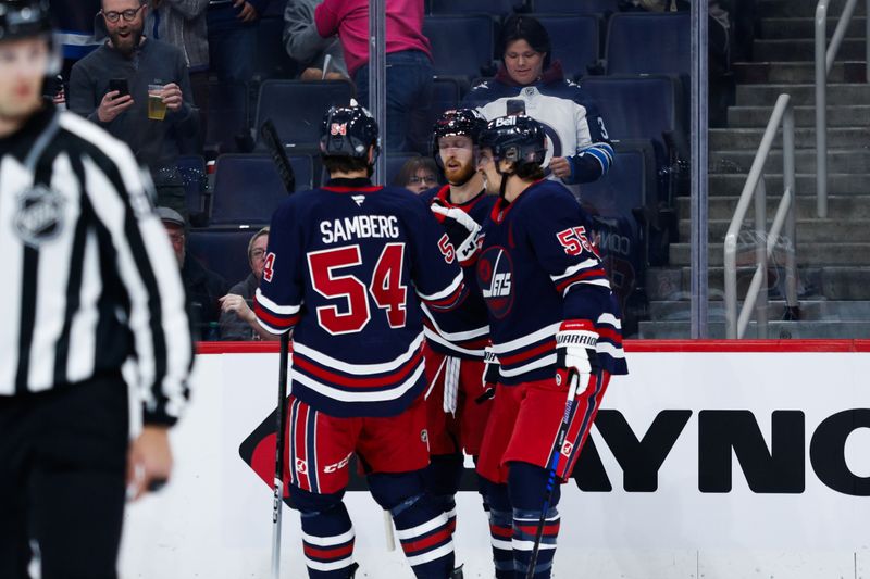 Oct 18, 2024; Winnipeg, Manitoba, CAN;  Winnipeg Jets forward Kyle Connor (81) is congratulated by his team mates on his goal against the San Jose Sharks during the second period at Canada Life Centre. Mandatory Credit: Terrence Lee-Imagn Images