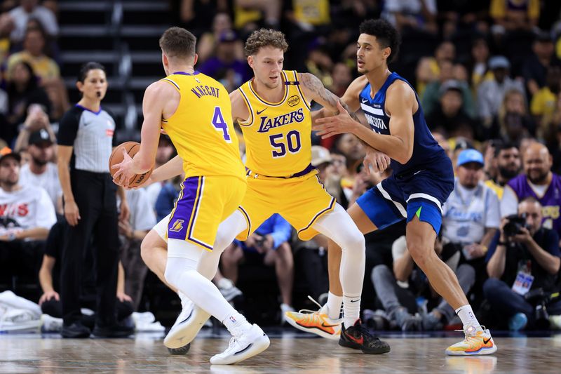 PALM SPRINGS, CALIFORNIA - OCTOBER 04: Kylor Kelly #50 hands off to Dalton Knecht #4 of the Los Angeles Lakers as Jesse Edwards #14 of the Minnesota Timberwolves defends during the second half of a game at Acrisure Arena on October 04, 2024 in Palm Springs, California.  (Photo by Sean M. Haffey/Getty Images)