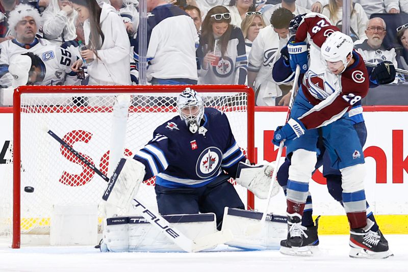 Apr 21, 2024; Winnipeg, Manitoba, CAN; Colorado Avalanche left wing Miles Wood (28) watches the puck go wide of Winnipeg Jets goaltender Connor Hellebuyck (37) in the second period in game one of the first round of the 2024 Stanley Cup Playoffs at Canada Life Centre. Mandatory Credit: James Carey Lauder-USA TODAY Sports