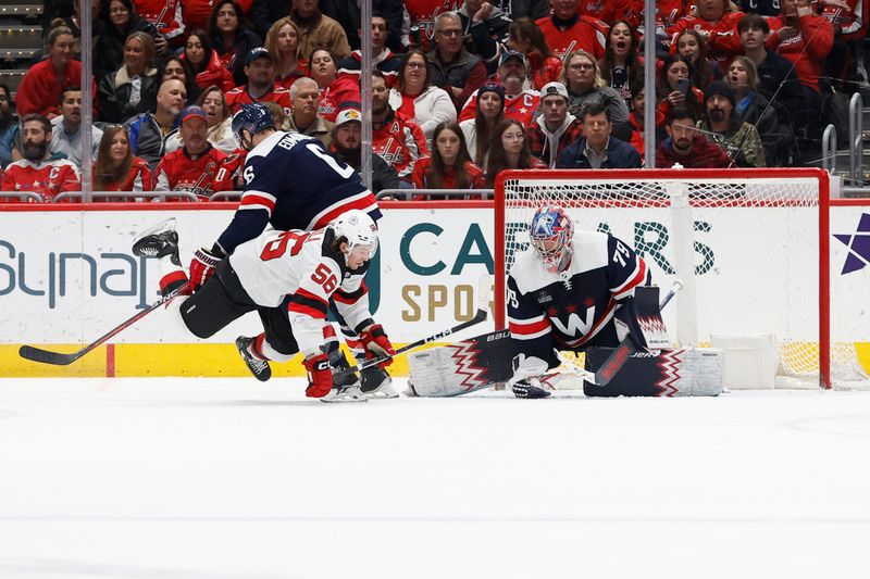 Feb 20, 2024; Washington, District of Columbia, USA; Washington Capitals goaltender Charlie Lindgren (79) makes a save in front of New Jersey Devils left wing Erik Haula (56) and Capitals defenseman Joel Edmundson (6) in the second period at Capital One Arena. Mandatory Credit: Geoff Burke-USA TODAY Sports