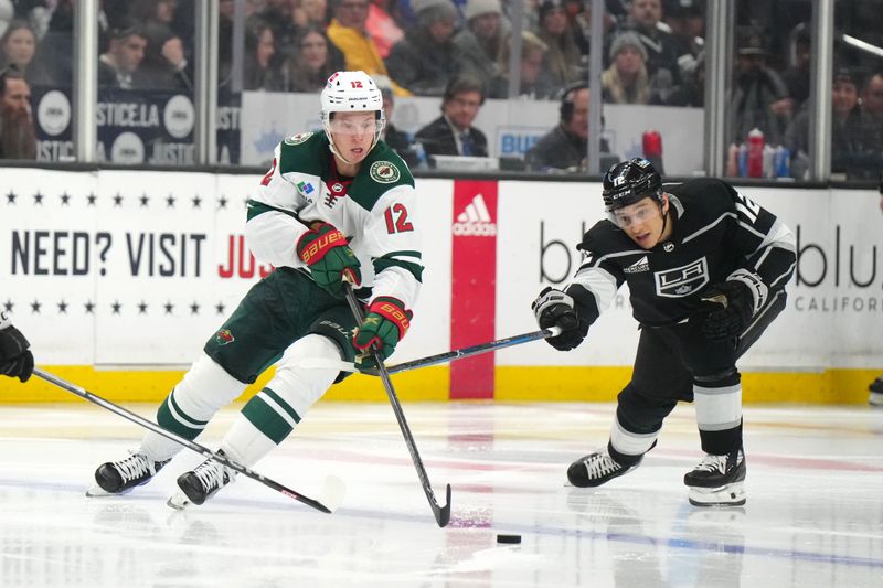 Apr 15, 2024; Los Angeles, California, USA; Minnesota Wild left wing Matt Boldy (left) and LA Kings left wing Trevor Moore reach for the puck in the third period at Crypto.com Arena. Mandatory Credit: Kirby Lee-USA TODAY Sports