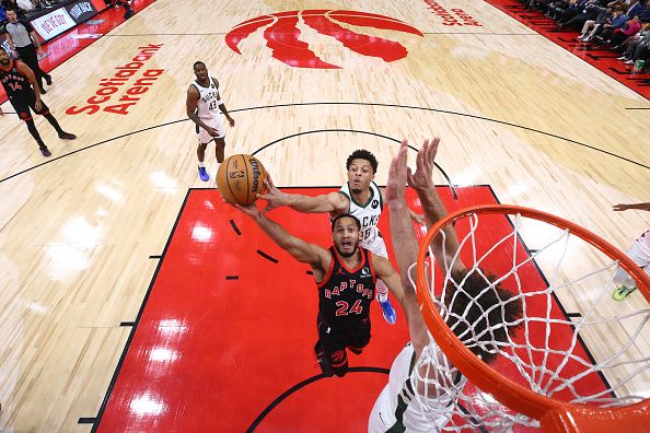 TORONTO, CANADA - NOVEMBER 15: Markquis Nowell #24 of the Toronto Raptors drives to the net as he's blocked by Lindell Wigginton #28 of the Milwaukee Bucks and Robin Lopez #42 of the Milwaukee Bucks during the second half of their NBA game against the Toronto Raptors at Scotiabank Arena on November 15, 2023 in Toronto, Canada. NOTE TO USER: User expressly acknowledges and agrees that, by downloading and or using this photograph, User is consenting to the terms and conditions of the Getty Images License Agreement. (Photo by Cole Burston/Getty Images)