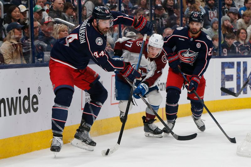 Apr 3, 2025; Columbus, Ohio, USA; Columbus Blue Jackets defenseman Erik Gudbranson (44) passes the puck as Colorado Avalanche left wing Parker Kelly (17) trails the play during the first period at Nationwide Arena. Mandatory Credit: Russell LaBounty-Imagn Images