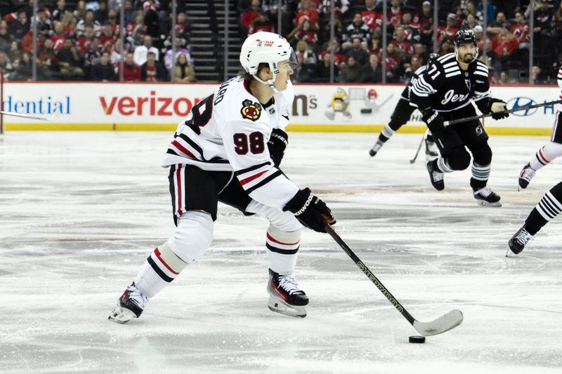 Dec 14, 2024; Newark, New Jersey, USA; Chicago Blackhawks center Connor Bedard (98) skates with the puck against the New Jersey Devils during the first period at Prudential Center. Mandatory Credit: John Jones-Imagn Images