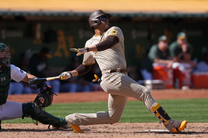 Sep 17, 2023; Oakland, California, USA; San Diego Padres left fielder Juan Soto (22) hits a home run against the Oakland Athletics during the seventh inning at Oakland-Alameda County Coliseum. Mandatory Credit: Darren Yamashita-USA TODAY Sports