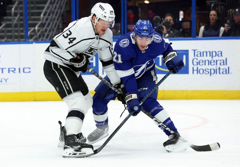 Jan 9, 2024; Tampa, Florida, USA; Tampa Bay Lightning center Brayden Point (21) skates with the puck as Los Angeles Kings right wing Arthur Kaliyev (34) defends during the first period at Amalie Arena. Mandatory Credit: Kim Klement Neitzel-USA TODAY Sports