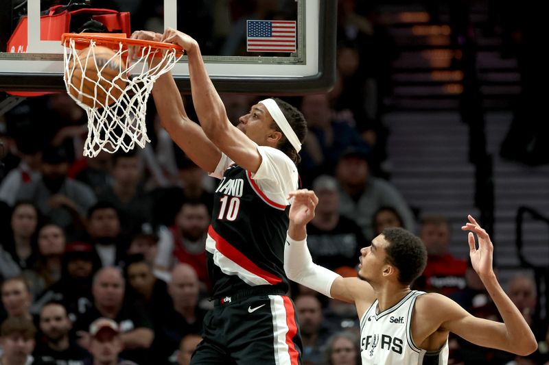 PORTLAND, OREGON - DECEMBER 28: Moses Brown #10 of the Portland Trail Blazers dunks against Victor Wembanyama #1 of the San Antonio Spurs during the third quarter at Moda Center on December 28, 2023 in Portland, Oregon. NOTE TO USER: User expressly acknowledges and agrees that, by downloading and or using this photograph, User is consenting to the terms and conditions of the Getty Images License Agreement. (Photo by Steph Chambers/Getty Images)