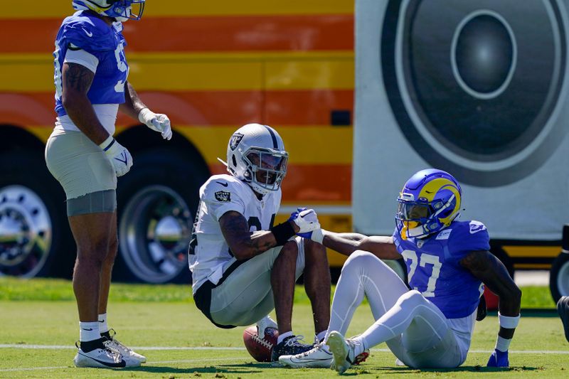 Las Vegas Raiders wide receiver Keelan Cole Sr. (84) helps up Los Angeles Rams cornerback Timarcus Davis (27) during a joint NFL football practice, Wednesday, Aug. 16, 2023, in Thousand Oaks, Calif. (AP Photo/Ryan Sun)