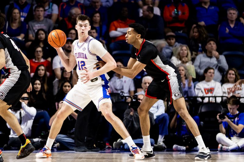 Jan 7, 2023; Gainesville, Florida, USA; Florida Gators forward Colin Castleton (12) posts up against Georgia Bulldogs center Frank Anselem (5) during the first half at Exactech Arena at the Stephen C. O'Connell Center. Mandatory Credit: Matt Pendleton-USA TODAY Sports