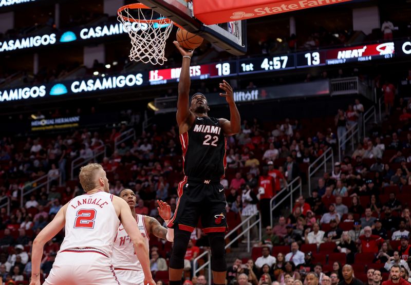 HOUSTON, TEXAS - APRIL 05: Jimmy Butler #22 of the Miami Heat shoots the ball while defended by Jabari Smith Jr. #10 of the Houston Rockets and Jock Landale #2 in the first half at Toyota Center on April 05, 2024 in Houston, Texas.  NOTE TO USER: User expressly acknowledges and agrees that, by downloading and or using this photograph, User is consenting to the terms and conditions of the Getty Images License Agreement. (Photo by Tim Warner/Getty Images)