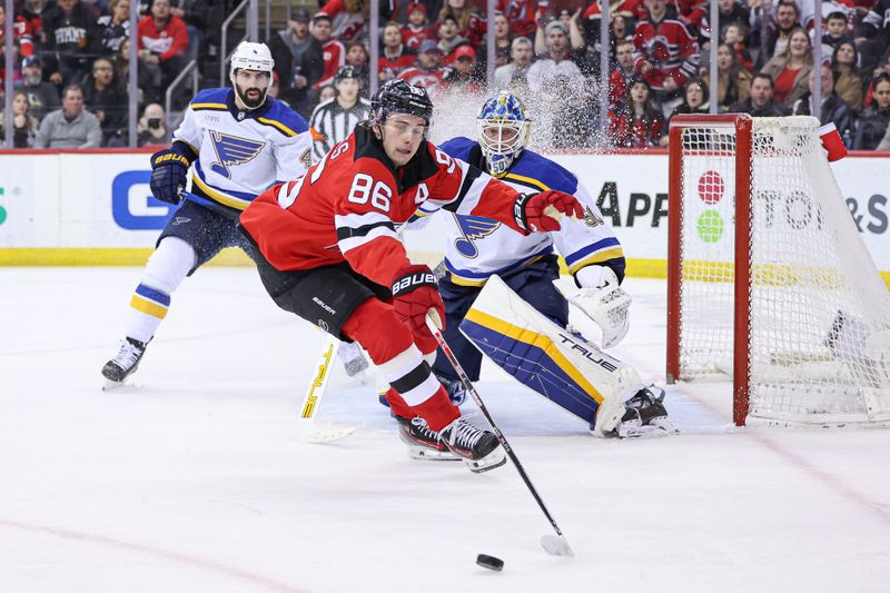 Mar 7, 2024; Newark, New Jersey, USA; New Jersey Devils center Jack Hughes (86) reaches for the puck in front of St. Louis Blues goaltender Jordan Binnington (50) and defenseman Nick Leddy (4) during the first period at Prudential Center. Mandatory Credit: Vincent Carchietta-USA TODAY Sports