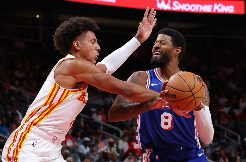 ATLANTA, GEORGIA - OCTOBER 14:  Paul George #8 of the Philadelphia 76ers draws a foul from Jalen Johnson #1 of the Atlanta Hawks during the second quarter at State Farm Arena on October 14, 2024 in Atlanta, Georgia.  NOTE TO USER: User expressly acknowledges and agrees that, by downloading and/or using this photograph, user is consenting to the terms and conditions of the Getty Images License Agreement.  (Photo by Kevin C. Cox/Getty Images)