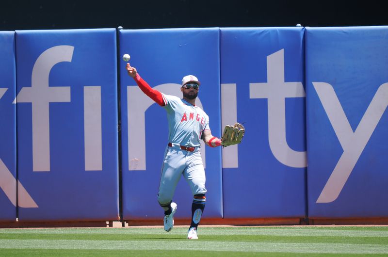 Jul 4, 2024; Oakland, California, USA; Los Angeles Angels center fielder Kevin Pillar (12) throws the ball infield after making a catch against the Oakland Athletics during the first inning at Oakland-Alameda County Coliseum. Mandatory Credit: Kelley L Cox-USA TODAY Sports