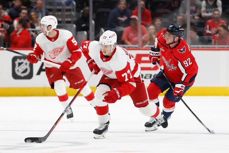 Sep 28, 2023; Washington, District of Columbia, USA; Detroit Red Wings defenseman Simon Edvinsson (77) skates with the puck as Washington Capitals center Evgeny Kuznetsov (92) chases in the third period at Capital One Arena. Mandatory Credit: Geoff Burke-USA TODAY Sports