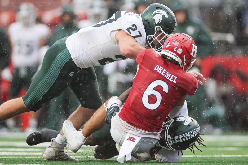 Oct 14, 2023; Piscataway, New Jersey, USA; Rutgers Scarlet Knights wide receiver Christian Dremel (6) is tackled by Michigan State Spartans linebacker Cal Haladay (27) and defensive back Angelo Grose (15) during the second half at SHI Stadium. Mandatory Credit: Vincent Carchietta-USA TODAY Sports