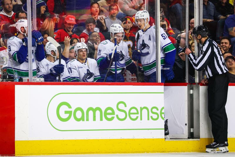 Dec 31, 2024; Calgary, Alberta, CAN; Vancouver Canucks players in the penalty box during the second period against the Calgary Flames at Scotiabank Saddledome. Mandatory Credit: Sergei Belski-Imagn Images