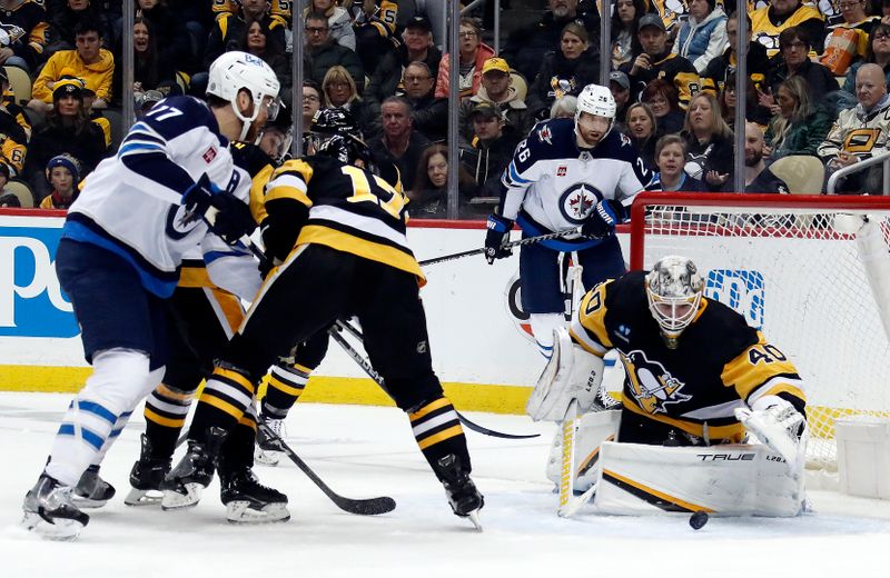 Jan 13, 2023; Pittsburgh, Pennsylvania, USA; Pittsburgh Penguins goaltender Dustin Tokarski (40) makes a save against Winnipeg Jets center Adam Lowry (17) during the second period at PPG Paints Arena. Mandatory Credit: Charles LeClaire-USA TODAY Sports