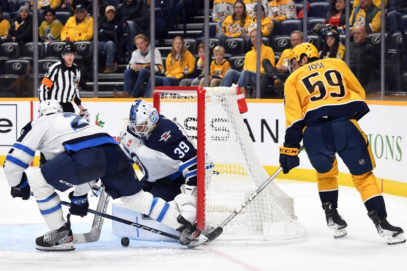 Nov 26, 2023; Nashville, Tennessee, USA; Winnipeg Jets goaltender Laurent Brossoit (39) makes a save on a shot by Nashville Predators defenseman Roman Josi (59) during the third period at Bridgestone Arena. Mandatory Credit: Christopher Hanewinckel-USA TODAY Sports