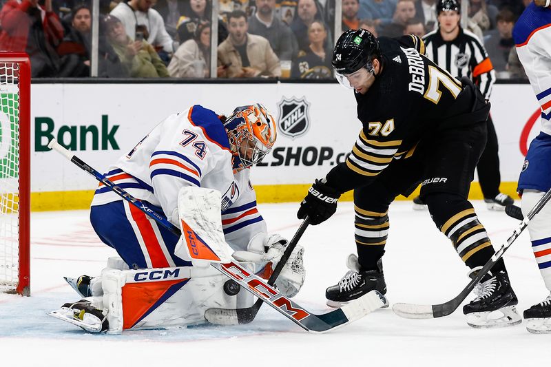 Mar 5, 2024; Boston, Massachusetts, USA; Boston Bruins left wing Jake DeBrusk (74) jams at a rebound at the crease of Edmonton Oilers goaltender Stuart Skinner (74) during the second period at TD Garden. Mandatory Credit: Winslow Townson-USA TODAY Sports