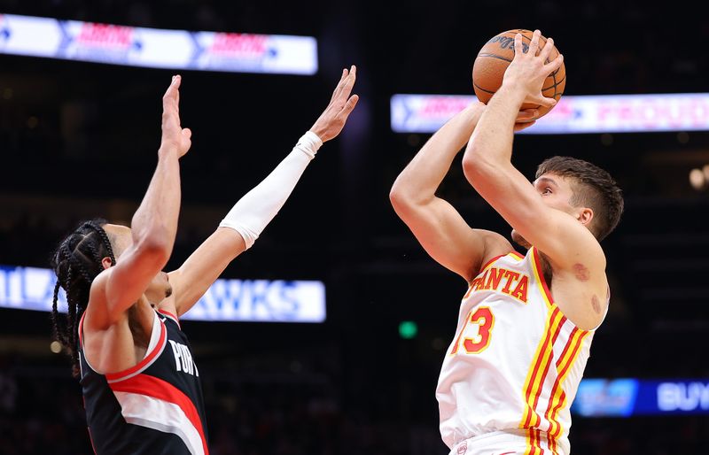 ATLANTA, GEORGIA - MARCH 27:  Bogdan Bogdanovic #13 of the Atlanta Hawks attempts a shot against Dalano Banton #5 of the Portland Trail Blazers during the third quarter at State Farm Arena on March 27, 2024 in Atlanta, Georgia.  NOTE TO USER: User expressly acknowledges and agrees that, by downloading and/or using this photograph, user is consenting to the terms and conditions of the Getty Images License Agreement.  (Photo by Kevin C. Cox/Getty Images)