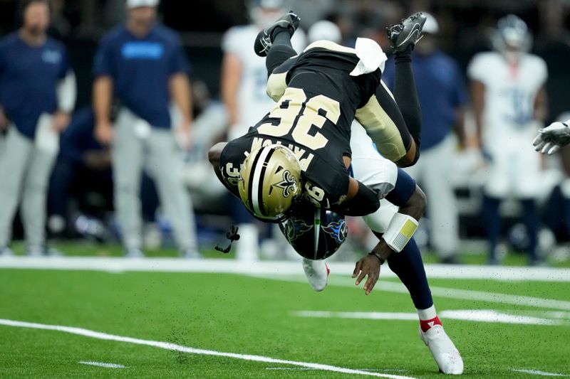 Tennessee Titans quarterback Malik Willis is tackled by New Orleans Saints cornerback Rico Payton during the second half of an NFL preseason football game, Sunday, Aug. 25, 2024, in New Orleans. (AP Photo/Gerald Herbert)