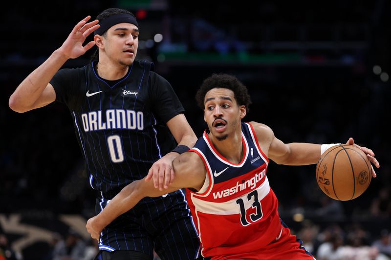 WASHINGTON, DC - MARCH 06: Jordan Poole #13 of the Washington Wizards dribbles past Anthony Black #0 of the Orlando Magic during the first half at Capital One Arena on March 06, 2024 in Washington, DC. NOTE TO USER: User expressly acknowledges and agrees that, by downloading and or using this photograph, User is consenting to the terms and conditions of the Getty Images License Agreement.  (Photo by Patrick Smith/Getty Images)