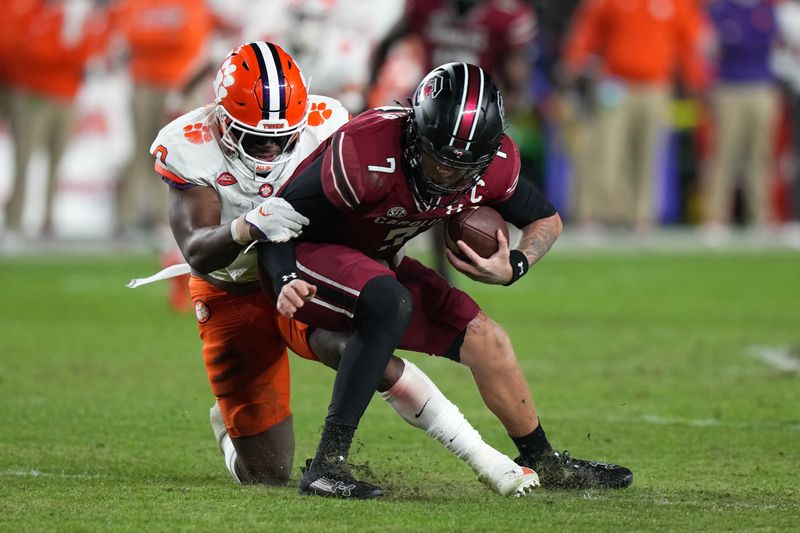 Nov 25, 2023; Columbia, South Carolina, USA; South Carolina Gamecocks quarterback Spencer Rattler (7) is sacked by Clemson Tigers linebacker Barrett Carter (0) in the first half at Williams-Brice Stadium. Mandatory Credit: David Yeazell-USA TODAY Sports