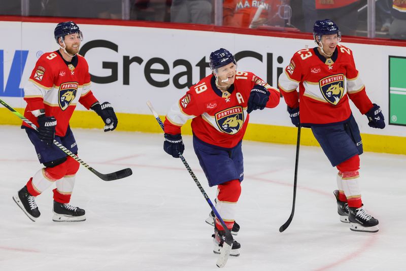 Apr 21, 2024; Sunrise, Florida, USA; Florida Panthers left wing Matthew Tkachuk (19) celebrates with center Sam Bennett (9) and center Carter Verhaeghe (23) after scoring against the Tampa Bay Lightning during the third period in game one of the first round of the 2024 Stanley Cup Playoffs at Amerant Bank Arena. Mandatory Credit: Sam Navarro-USA TODAY Sports