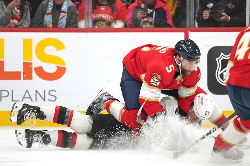 Feb 20, 2024; Sunrise, Florida, USA; Florida Panthers defenseman Aaron Ekblad (5) gets tangled up Ottawa Senators left wing Parker Kelly (27) with during the first period at Amerant Bank Arena. Mandatory Credit: Jim Rassol-USA TODAY Sports