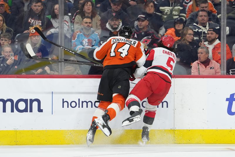 Dec 13, 2025; Philadelphia, Pennsylvania, USA; Philadelphia Flyers center Sean Couturier (14) hits Carolina Hurricanes defenseman Jalen Chatfield (5) in the second period at Xfinity Mobile Arena. Mandatory Credit: Kyle Ross-Imagn Images